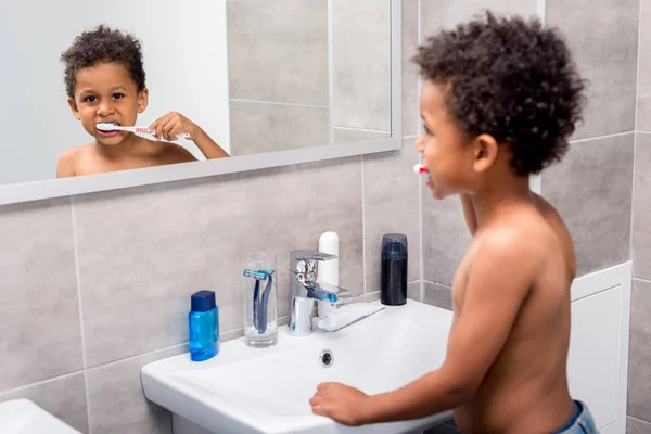 Afro kid brushing teeth — Stock Photo