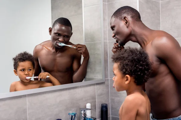 Father and son brushing teeth — Stock Photo