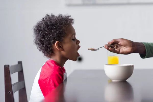 Pai alimentando seu filho com café da manhã — Fotografia de Stock