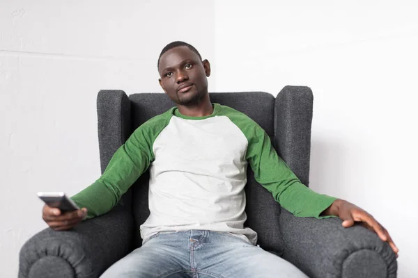 Homme dans le fauteuil regarder la télévision — Photo de stock