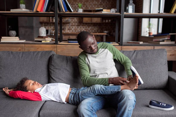 Father putting shoes on son — Stock Photo