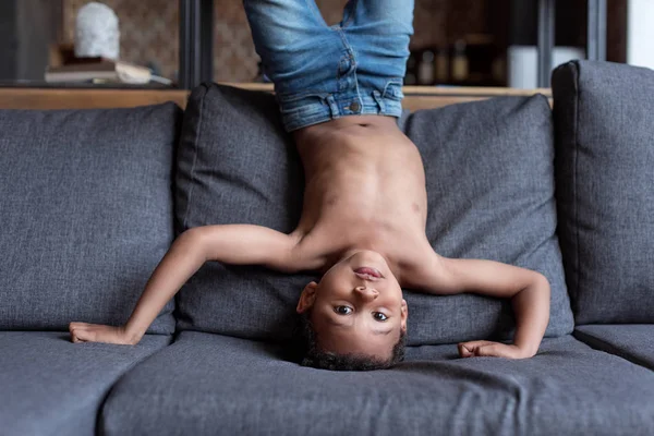 Enfant debout à l'envers sur le canapé — Photo de stock