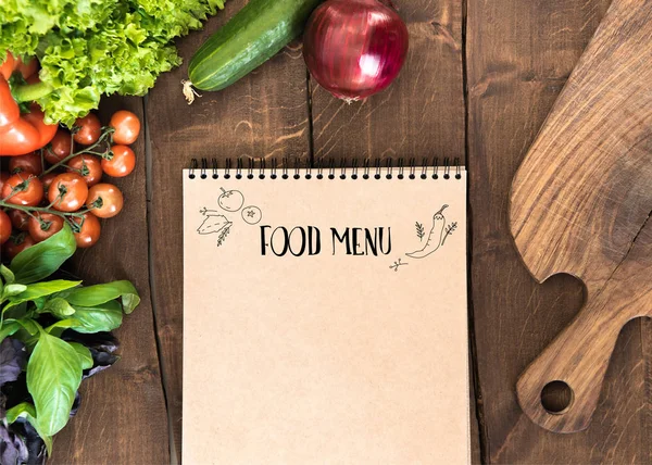 Bloc de notas con verduras crudas en la mesa - foto de stock