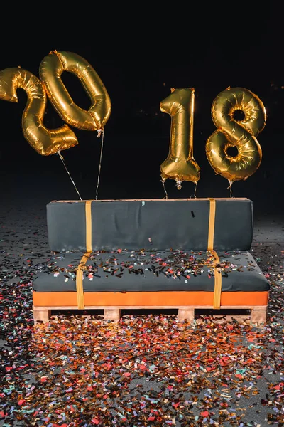 Couch with confetti and new year balloons — Stock Photo