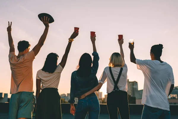 Friends on roof at sunset — Stock Photo