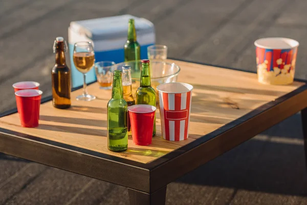 Bottles, glasses and paper bowls for popcorn — Stock Photo