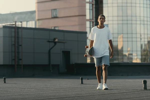 Uomo che cammina con skateboard — Foto stock