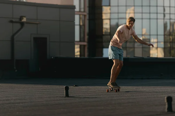 Человек на скейтборде на крыше — стоковое фото