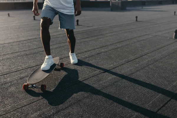 Homme chevauchant sur skateboard sur le toit — Photo de stock