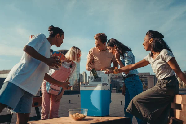 Friends with fridge of beer on roof — Stock Photo