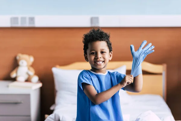 Afro-americano menino vestindo luva médica — Fotografia de Stock