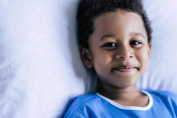 African american boy lying in bed — Stock Photo