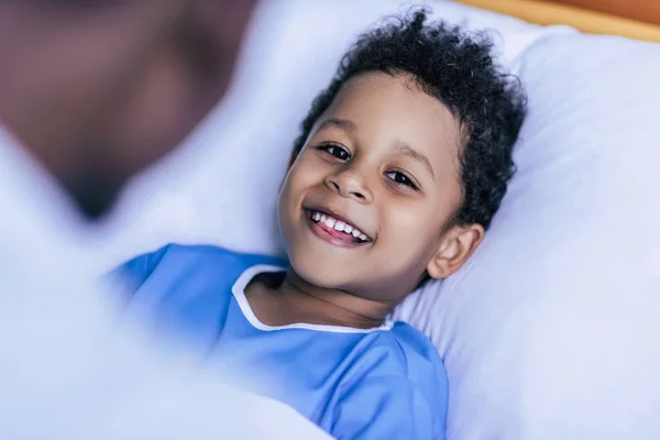 African american boy lying in bed — Stock Photo