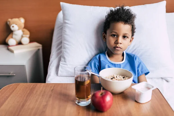 Garçon afro-américain avec petit déjeuner en clinique — Photo de stock