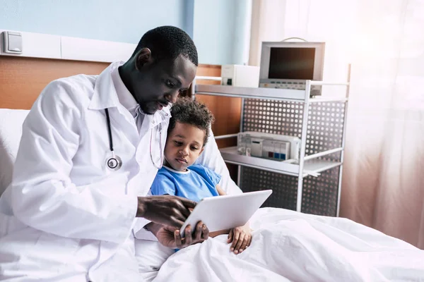 Medico afroamericano e paziente con compressa — Foto stock