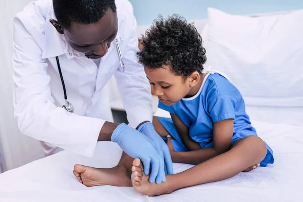 Médico afroamericano examinando paciente - foto de stock