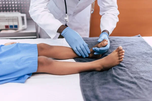 Médico afroamericano examinando paciente - foto de stock