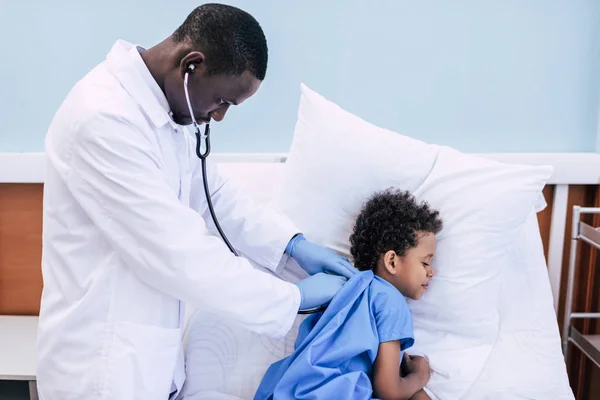 Médico afroamericano y niño pequeño - foto de stock