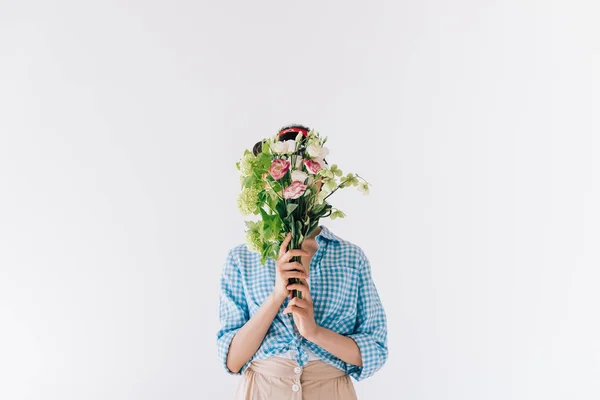 Woman covering face with flowers — Stock Photo