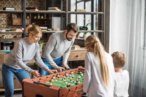 Parents and kids playing table football — Stock Photo