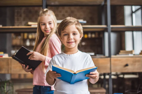 Hermanos sonrientes con libros - foto de stock