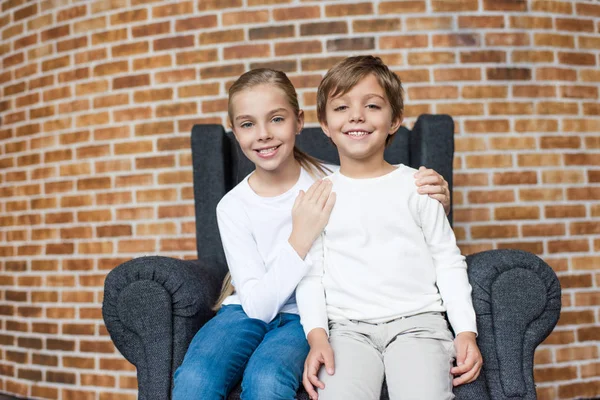 Hermanos descansando en el sillón - foto de stock