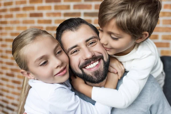 Niños abrazando padre — Stock Photo