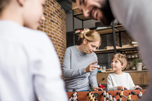 Parents and kids playing table football — Stock Photo