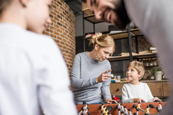 Genitori e bambini che giocano a calcio balilla — Foto stock