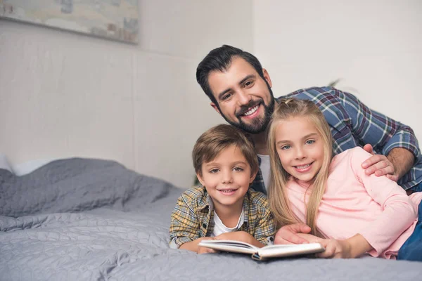 Family reading book together — Stock Photo