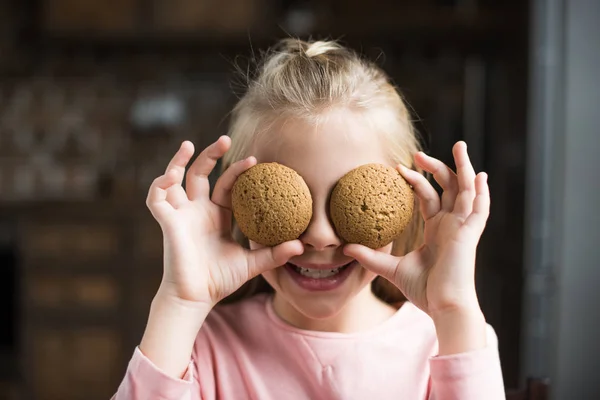 Bambino sorridente con biscotti — Foto stock