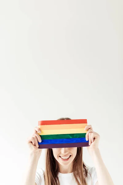 Mulher cobrindo a testa com bandeira do arco-íris — Fotografia de Stock