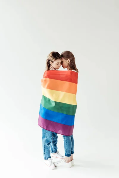 Lesbianas pareja envuelta en arco iris bandera - foto de stock