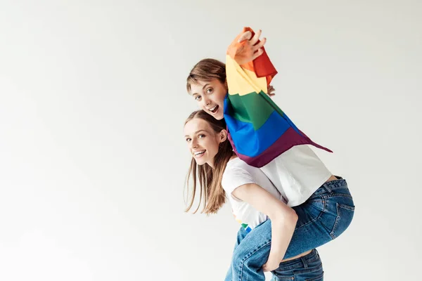 Mujer dando piggyback a novia con bandera - foto de stock