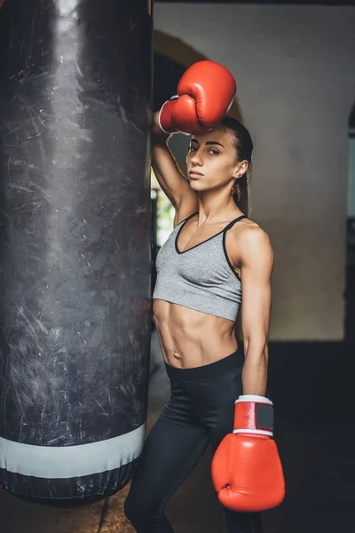 Boxeador femenino con saco de boxeo - foto de stock