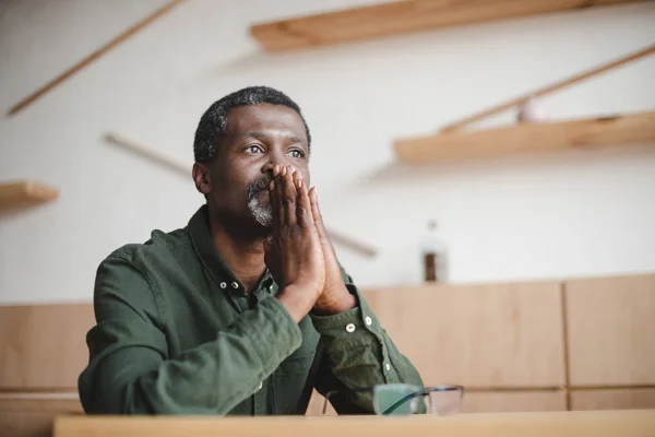 Homme mûr réfléchi assis dans le café — Photo de stock