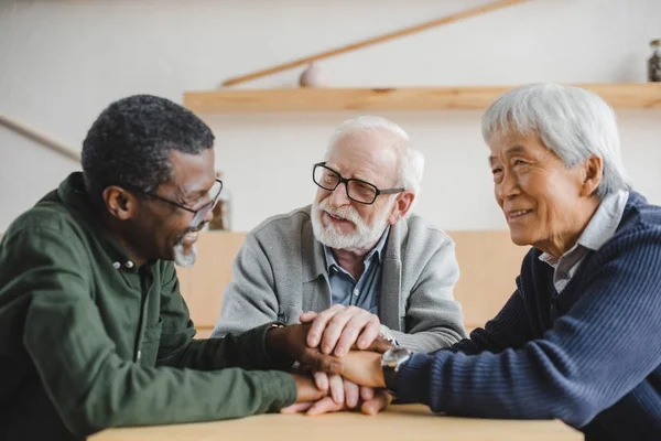 Amigos mayores haciendo gesto de equipo — Stock Photo