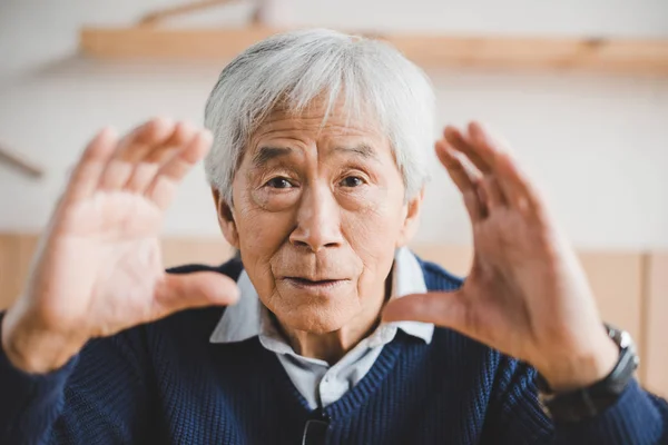 Asiatischer Mann fertigt Rahmen mit Händen — Stockfoto