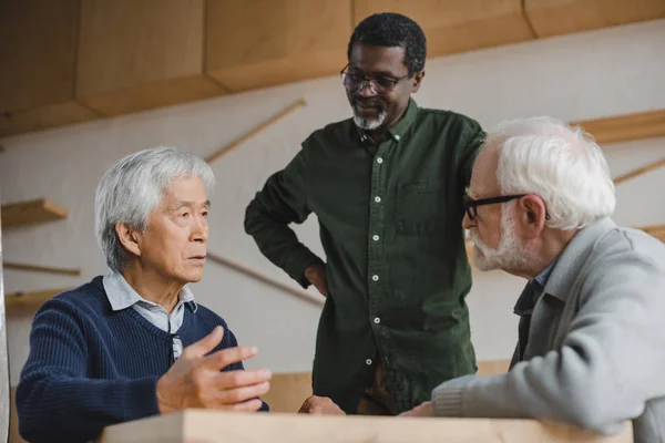 Hommes âgés parlant dans le café — Photo de stock