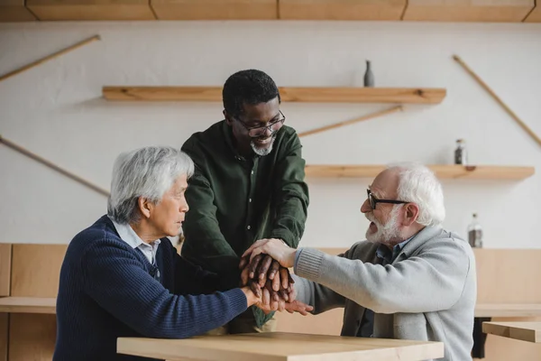 Amigos mayores haciendo gesto de equipo - foto de stock