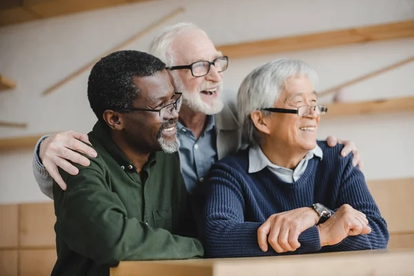 Senior friends embracing and looking away — Stock Photo