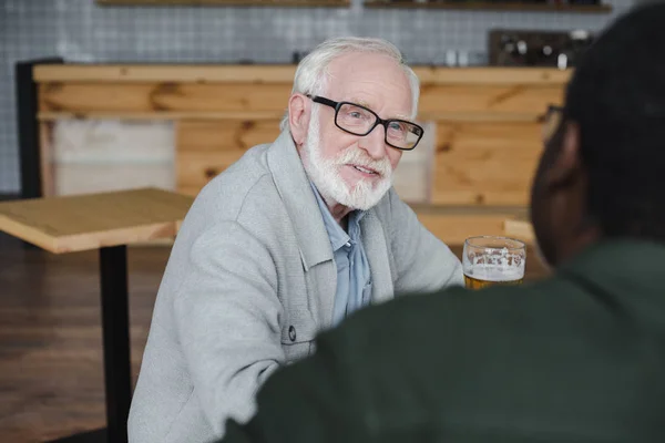 Amici anziani che parlano e bevono birra — Foto stock