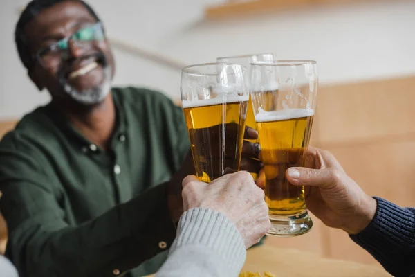 Homme cliquetis verres de bière avec des amis — Photo de stock