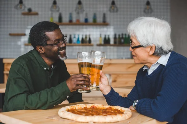 Amici anziani clinking bicchieri di birra — Foto stock