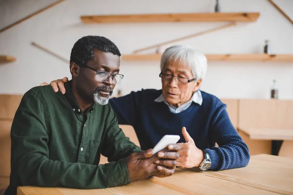 Senioren schauen aufs Smartphone — Stockfoto