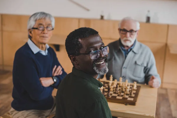 Senior friends playing chess — Stock Photo