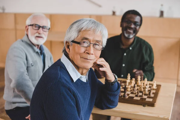 Старші друзі грають у шахи — стокове фото