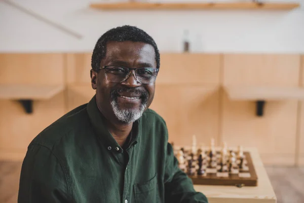 Hombre maduro sonriente con ajedrez - foto de stock