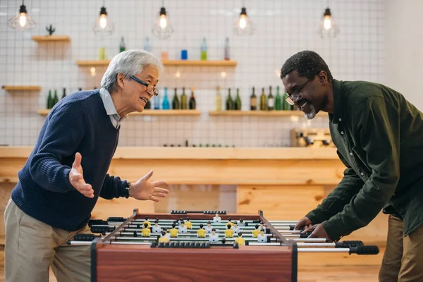Senior friends playing table football — Stock Photo