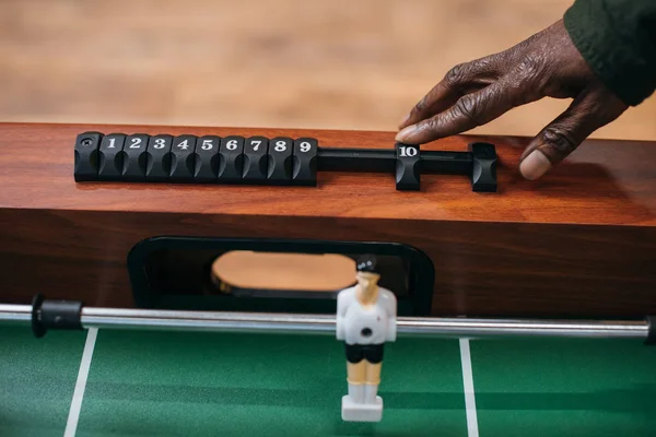 Man moving counter on table football — Stock Photo